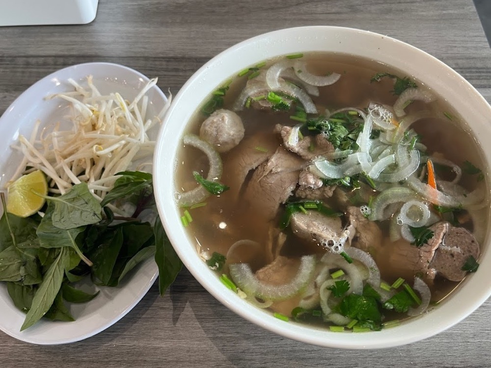 Phở with fresh herbs, bean sprouts, and lime